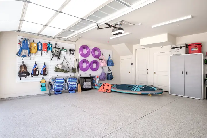 Wide view of the garage gear wall with paddleboards and family adventure equipment